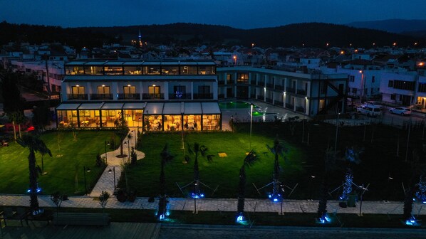 A hotel with a central courtyard, multiple floors, and a prominent building with a lit facade. - Sunsan Hotel (Çanakkale)