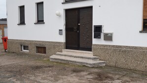 A building with a black door, small windows, and a stone base. - Ferienzimmer 1 Saarlouis (Saarlouis)