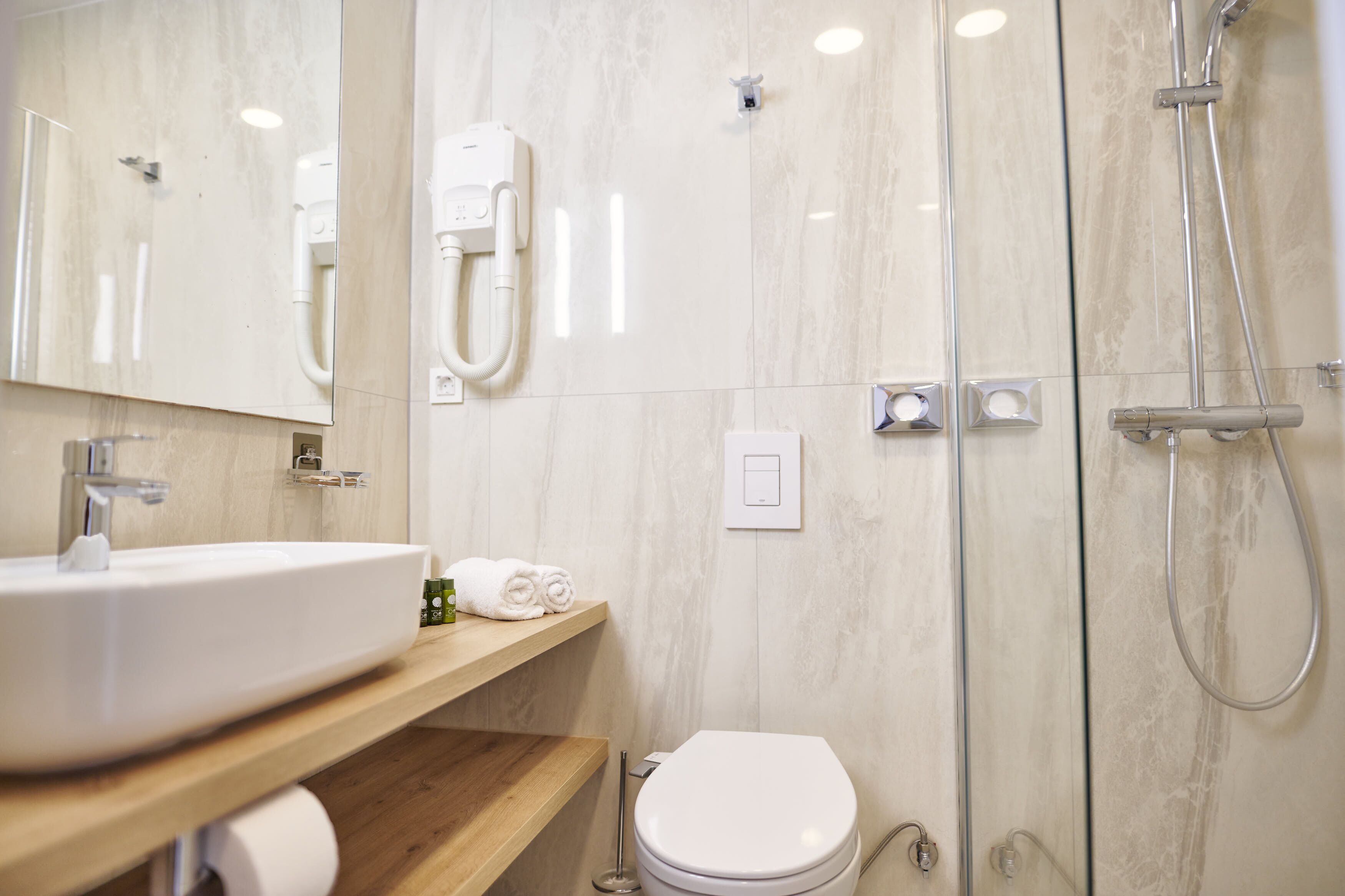 A modern bathroom with a sink, toilet, and shower.