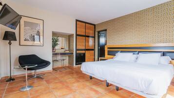 Una habitación de hotel moderna con una cama grande, un escritorio, una silla y un televisor.