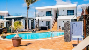 A modern two-story building with a swimming pool, outdoor seating, and a palm tree. - El Hotelito Del Golfo (Yaiza)