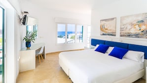 A modern bedroom with a large bed, a desk, and a view of the sea. - El Hotelito Del Golfo (Yaiza)