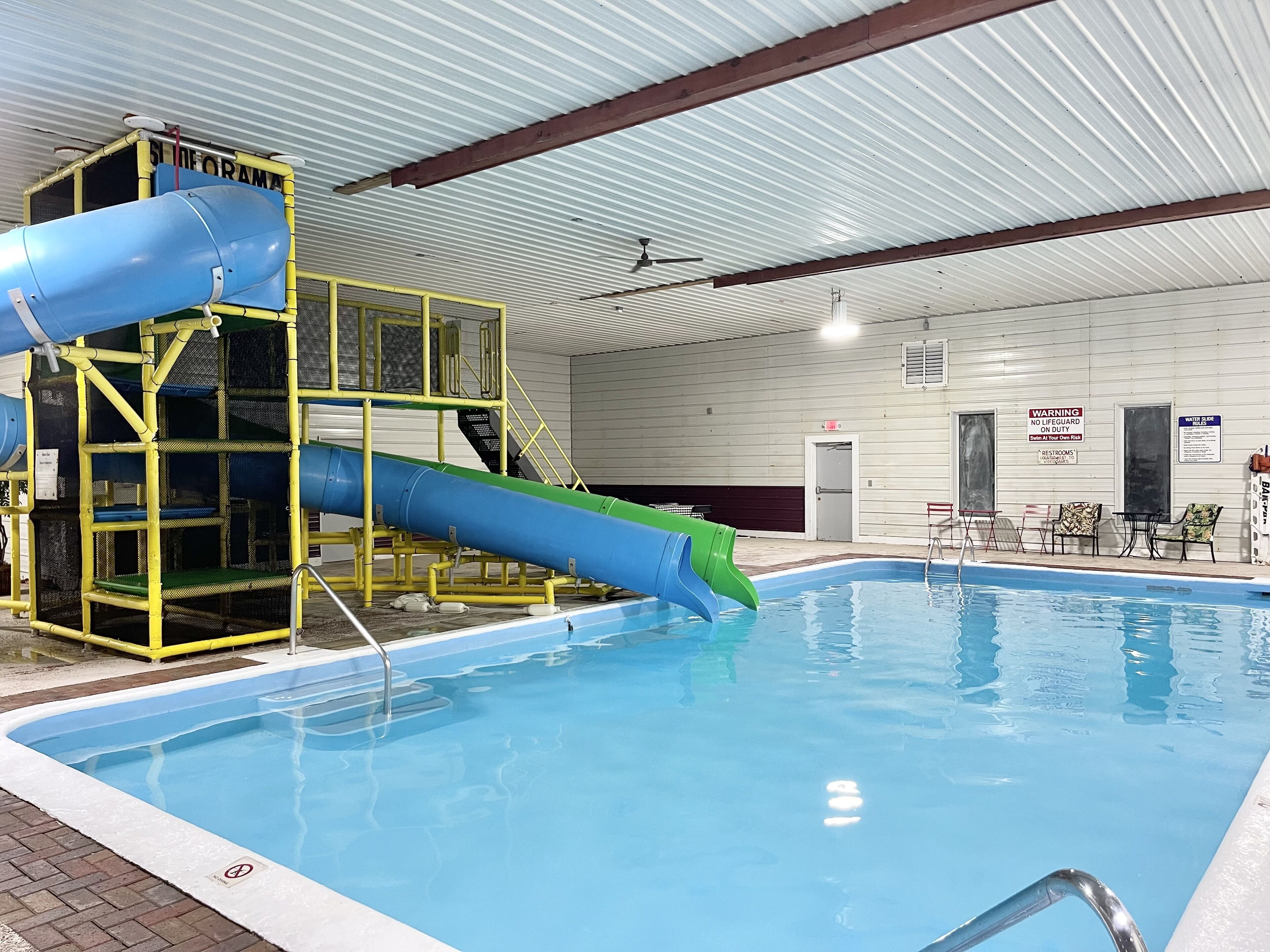 Piscina interna com escorregador e posto de salva-vidas.