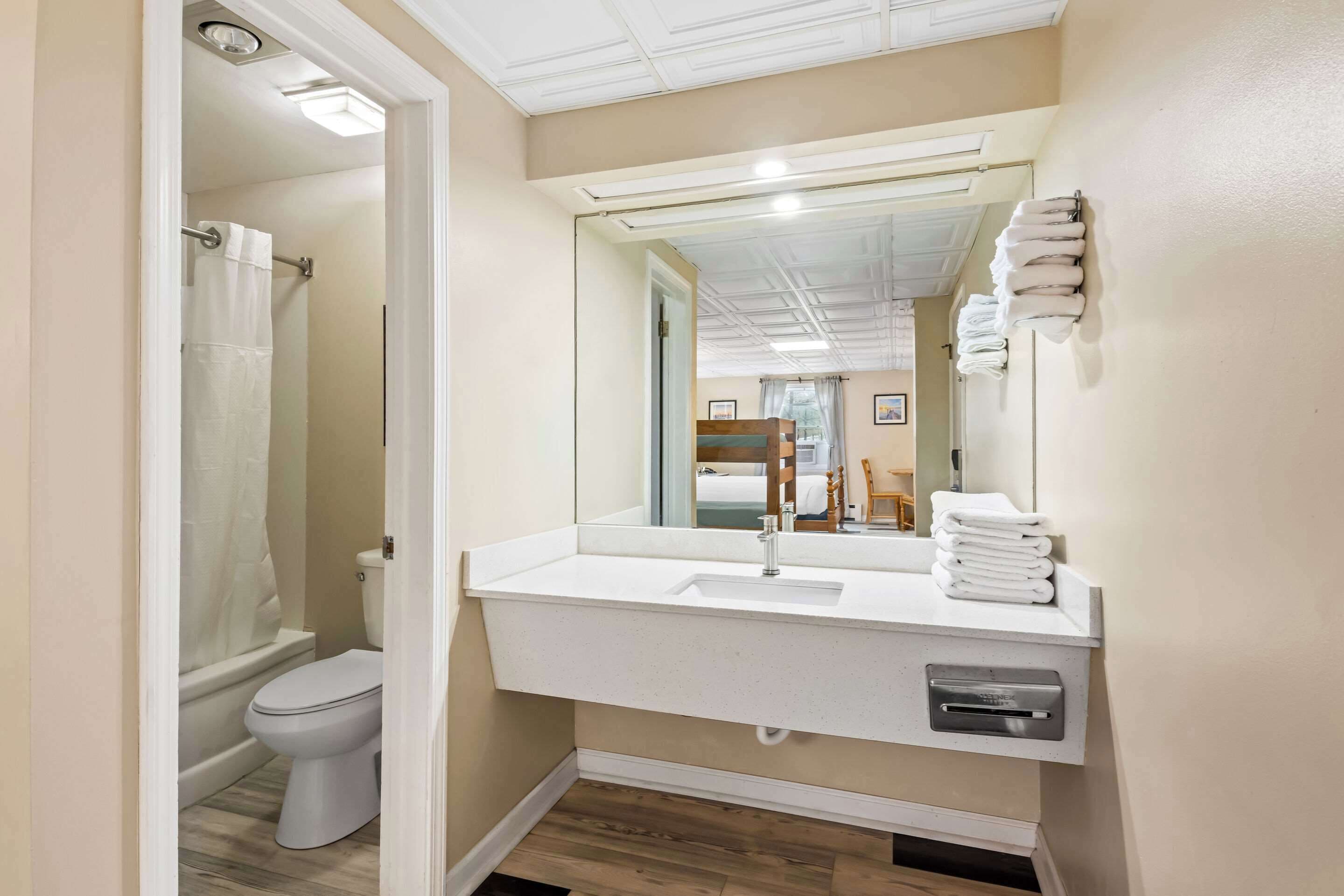 Un bagno moderno con lavandino, specchio e portasciuga in bianco.