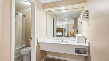 Un bagno moderno con lavandino, specchio e portasciuga in bianco.