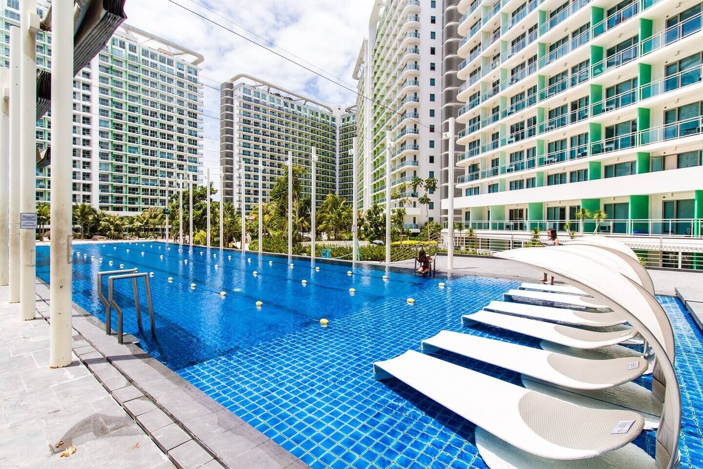 A swimming pool with steps leading into it, surrounded by high-rise buildings.