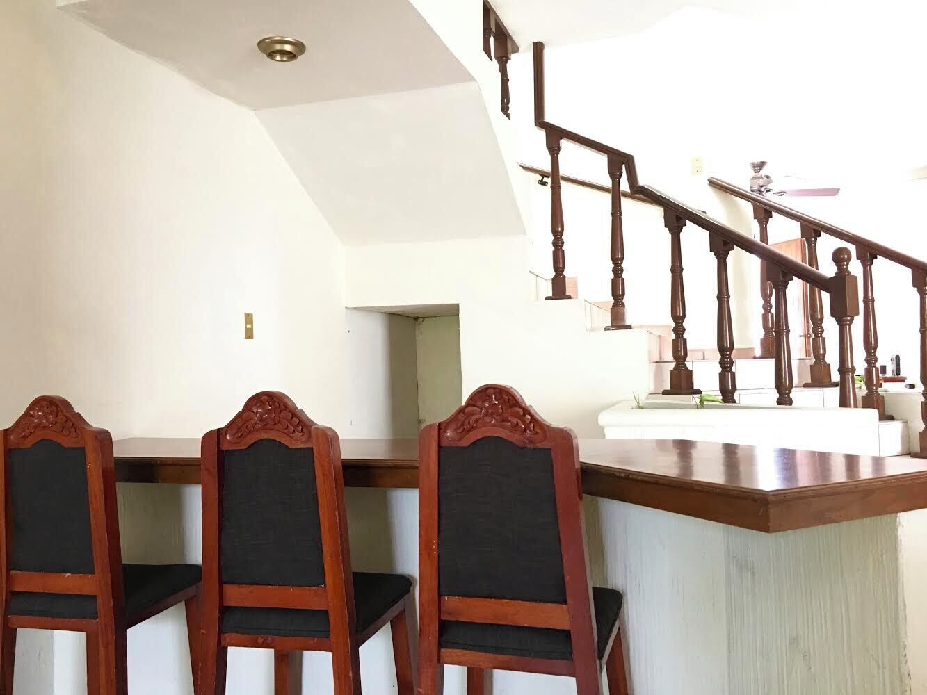 Un espace repas avec des chaises en bois et un comptoir de bar.