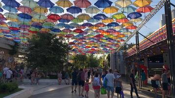 A public square with a canopy of colorful umbrellas overhead.