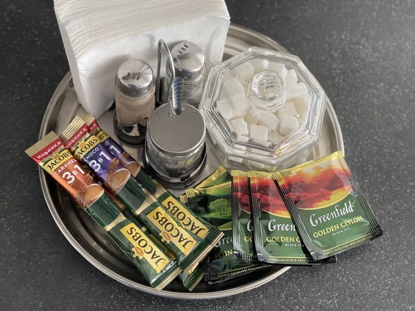 A tray with various tea bags, a salt shaker, a pepper shaker, and a container of sugar cubes. - The Rooms Apart (Odesa)