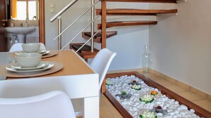 A dining area with a table, chairs, and a staircase. - Valena Stylish Home -15 min to Elafonisi (Kissamos)