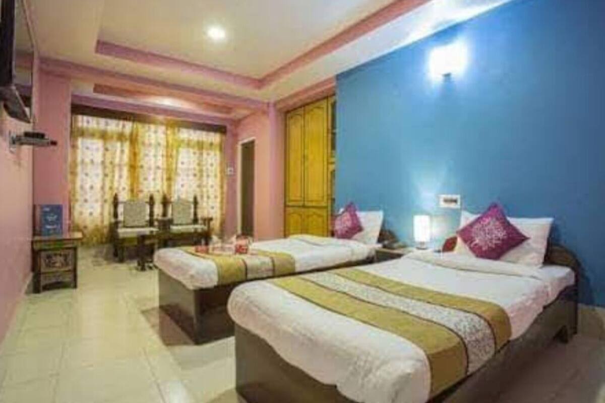 A hotel room with two beds, a desk, and a chair.