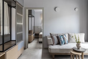 A modern living room with a sofa, a small round table, and a potted plant.