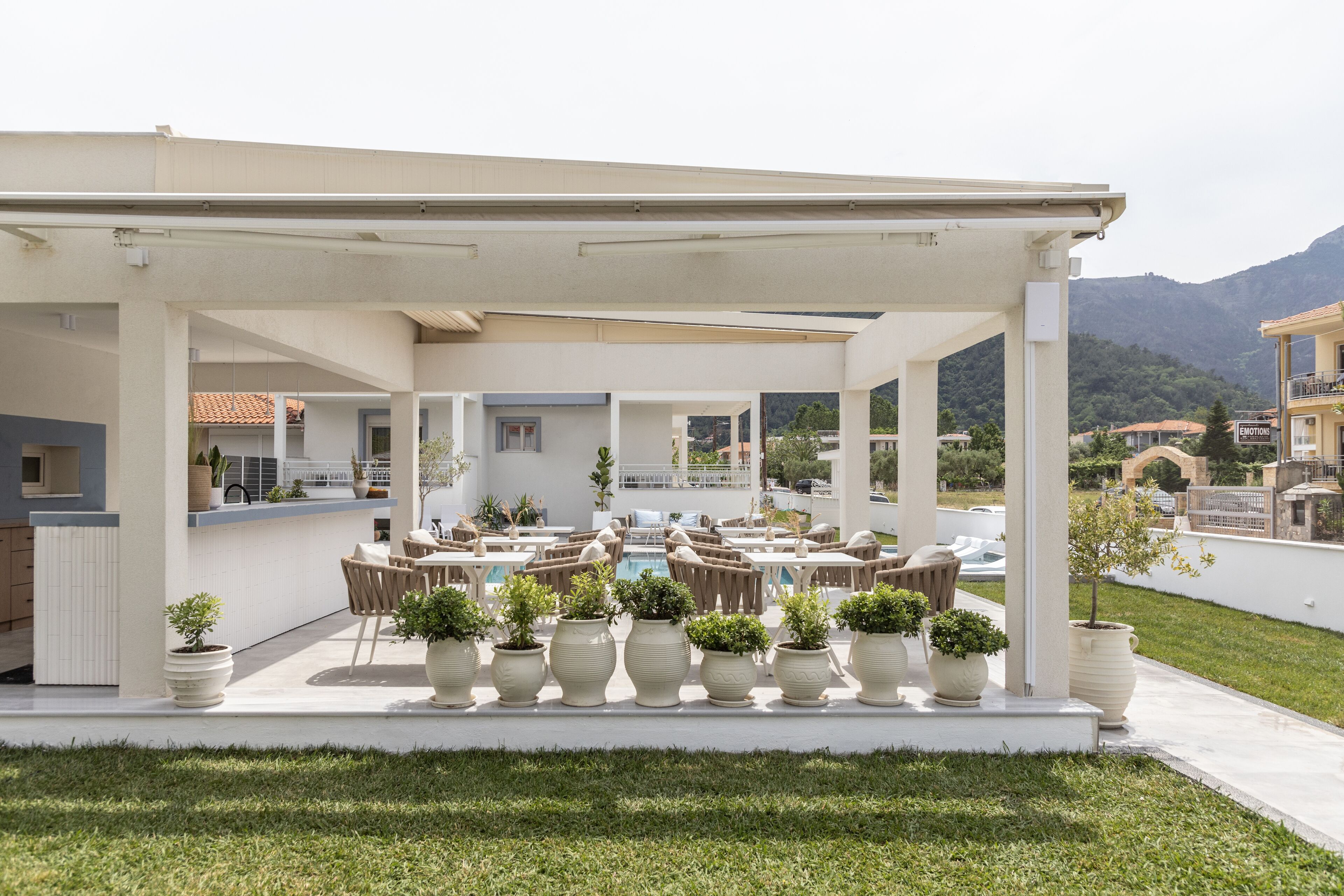 A covered outdoor area with multiple seating arrangements and potted plants.
