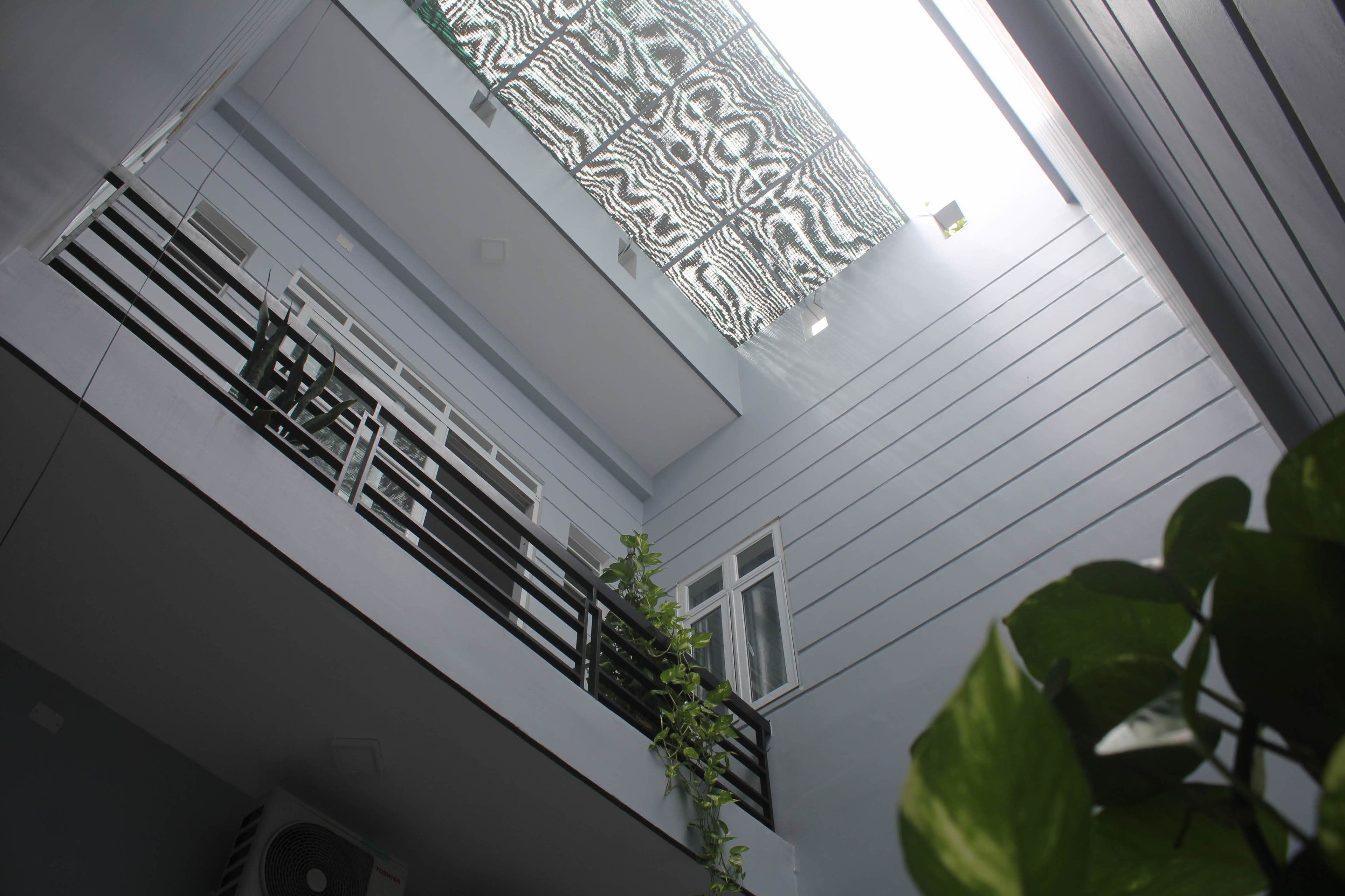 A modern building with a balcony, a patterned ceiling, and a window.