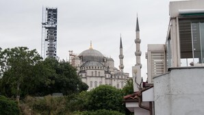 A mosque with a large dome and two minarets, surrounded by trees and a construction crane. - Hotel Estambul (Istanbul)