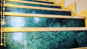 Un escalier doté d’une surface réfléchissante et d’un décor à motifs.