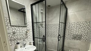 A modern bathroom with a glass-enclosed shower, a pedestal sink, and a toilet. - Hotel Estambul (Istanbul)