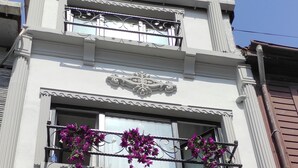 A multi-story building with balconies adorned with purple flowers. - Hotel Estambul (Istanbul)