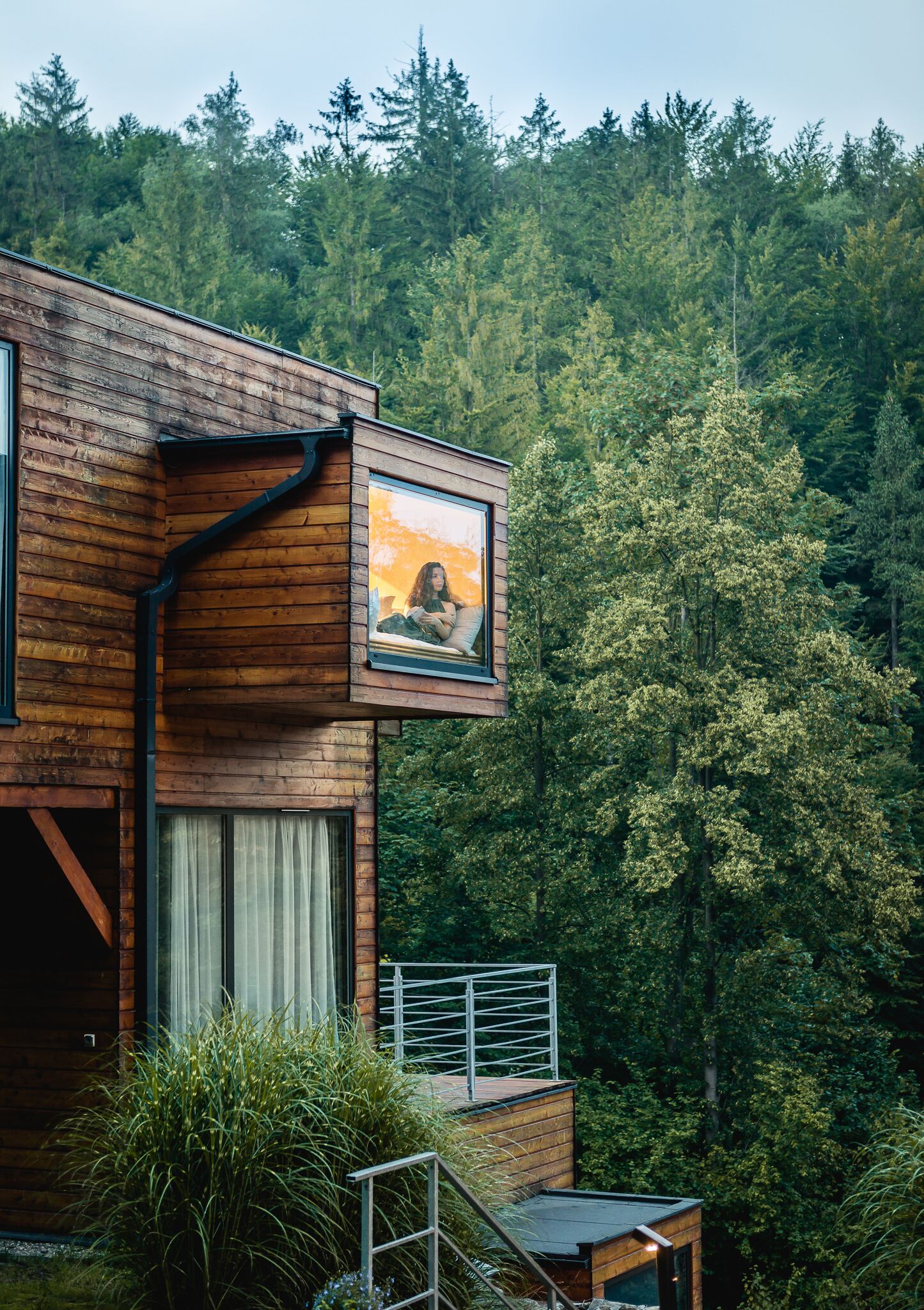 Eine moderne Holzhütte mit einem großen Fenster und einem gerahmten Bild einer Person.
