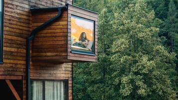 A modern wooden cabin with a large window and a framed picture of a person.