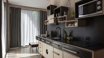 Una cucina moderna con forno a microonde integrato, pensili in legno e un'ampia finestra con tende.