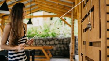 A person holding a fishing rod in a wooden structure with a stone wall and a wooden door.