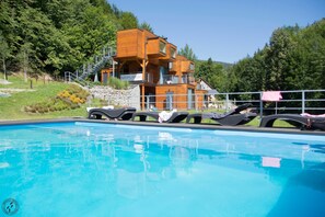 Piscine extérieure en saison, chaises longues
