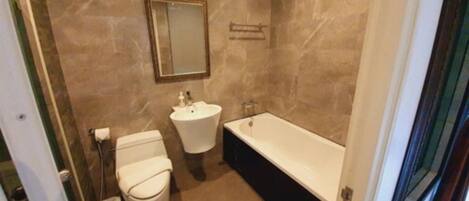 Ein Badezimmer mit Toilette, Waschbecken und Badewanne.