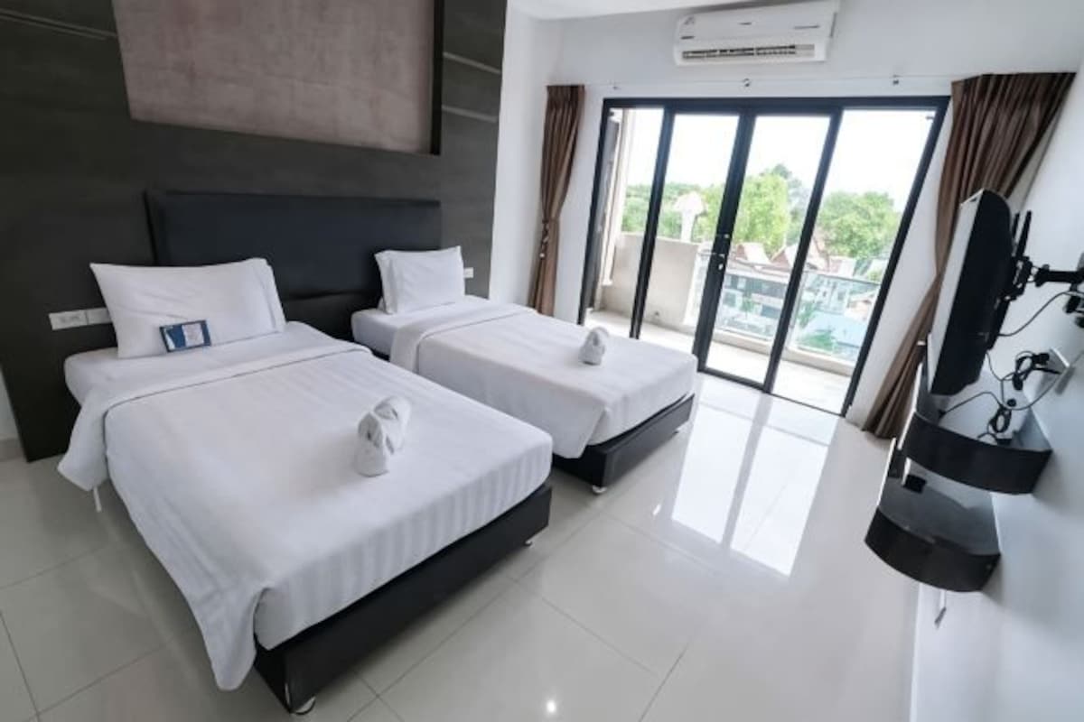 Une chambre d’hôtel avec deux lits, un téléviseur à écran plat et un balcon avec vue.