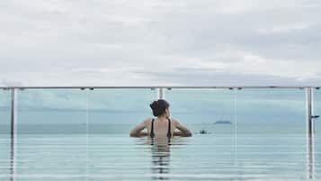 Una piscina al aire libre, sillones reclinables de piscina