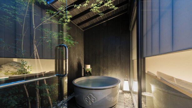 Un moderno espacio de spa con jacuzzi, paredes de madera y cerramiento de vidrio.