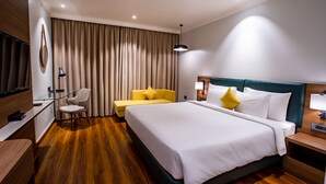 Une chambre d’hôtel avec un grand lit, un bureau, une chaise et un canapé.