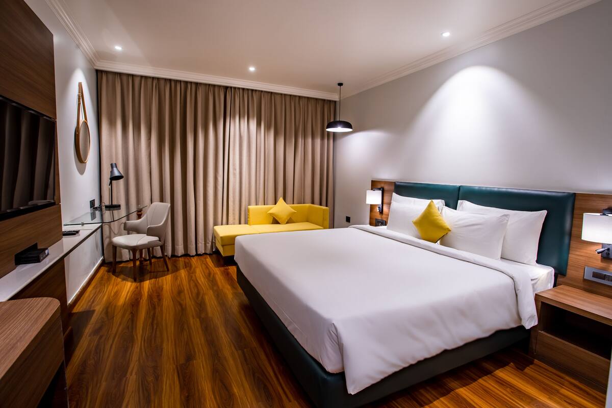 Une chambre d’hôtel avec un grand lit, un bureau, une chaise et un canapé.