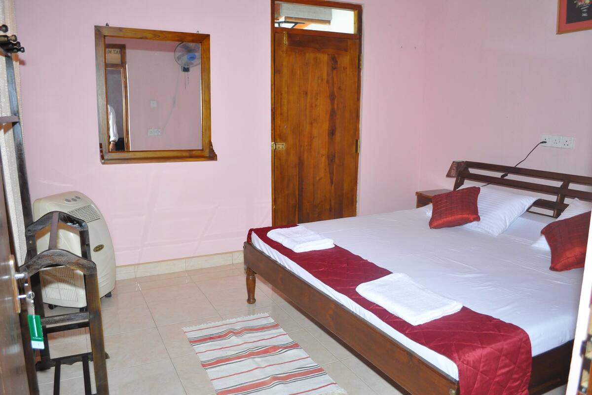 Un dormitorio con una cama de madera, un espejo, un calentador y una silla.
