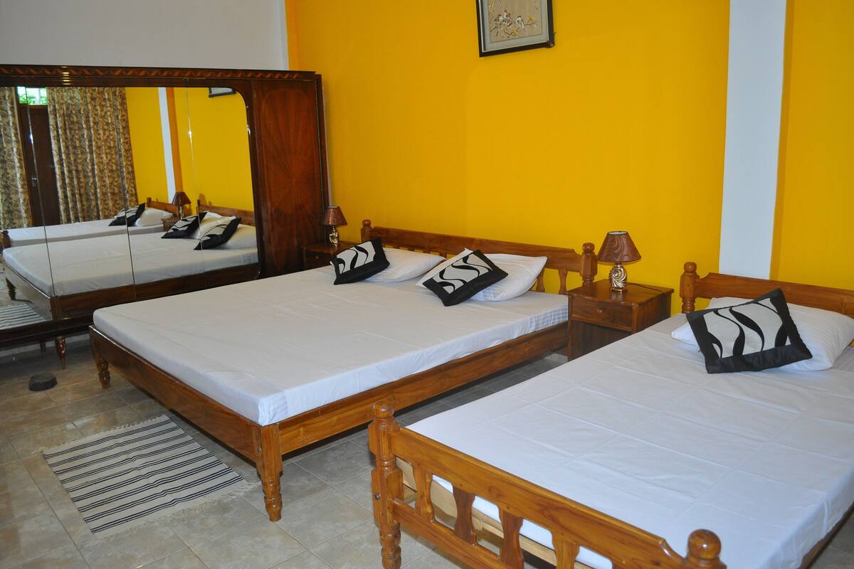 Una habitación de hotel con dos camas de madera, ropa de cama blanca y almohadas estampadas en blanco y negro.