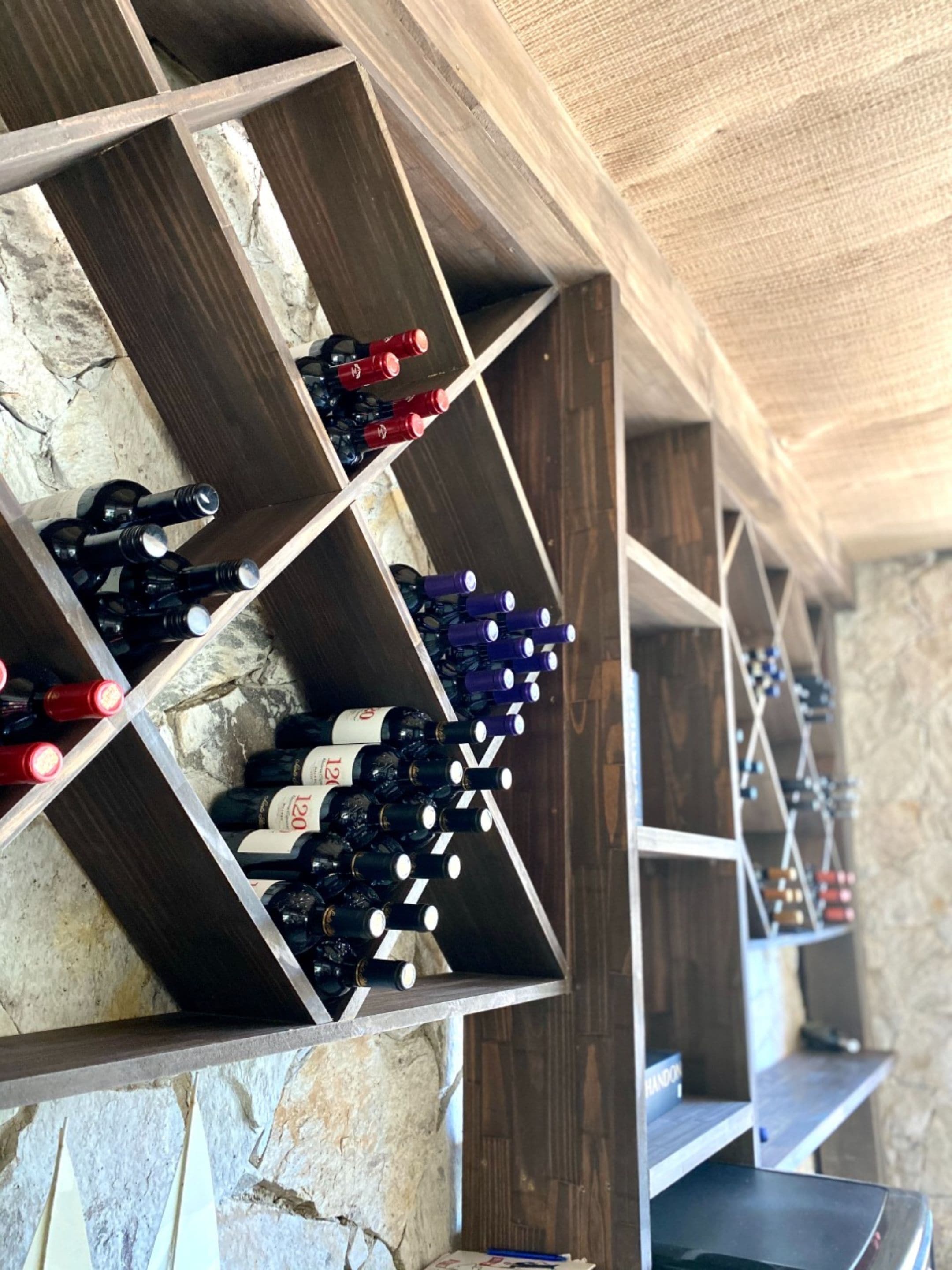 Una estantería para vinos con varios niveles que albergan botellas.