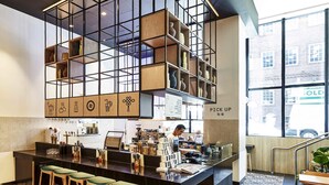Un área de bar moderna con mostrador, taburetes y techo con diseño de cuadrícula.