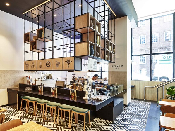 A modern bar area with a counter, stools, and a grid-patterned ceiling.