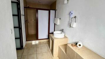 A bathroom with a sink, towel rack, and a toilet paper holder.