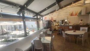 Un restaurant doté d’une terrasse, d’un espace cuisine et offrant une vue sur la rue.