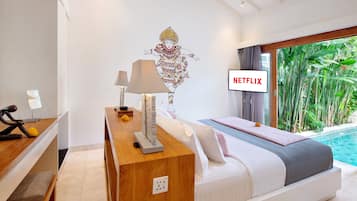 Une chambre d’hôtel moderne équipée d’un lit, d’une table de chevet, d’une lampe et d’un téléviseur fixé au mur qui affiche l’application « NETFLIX ».