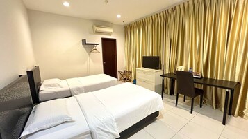 Quarto de hotel com duas camas, uma escrivaninha, uma cadeira, uma televisão e cortina.