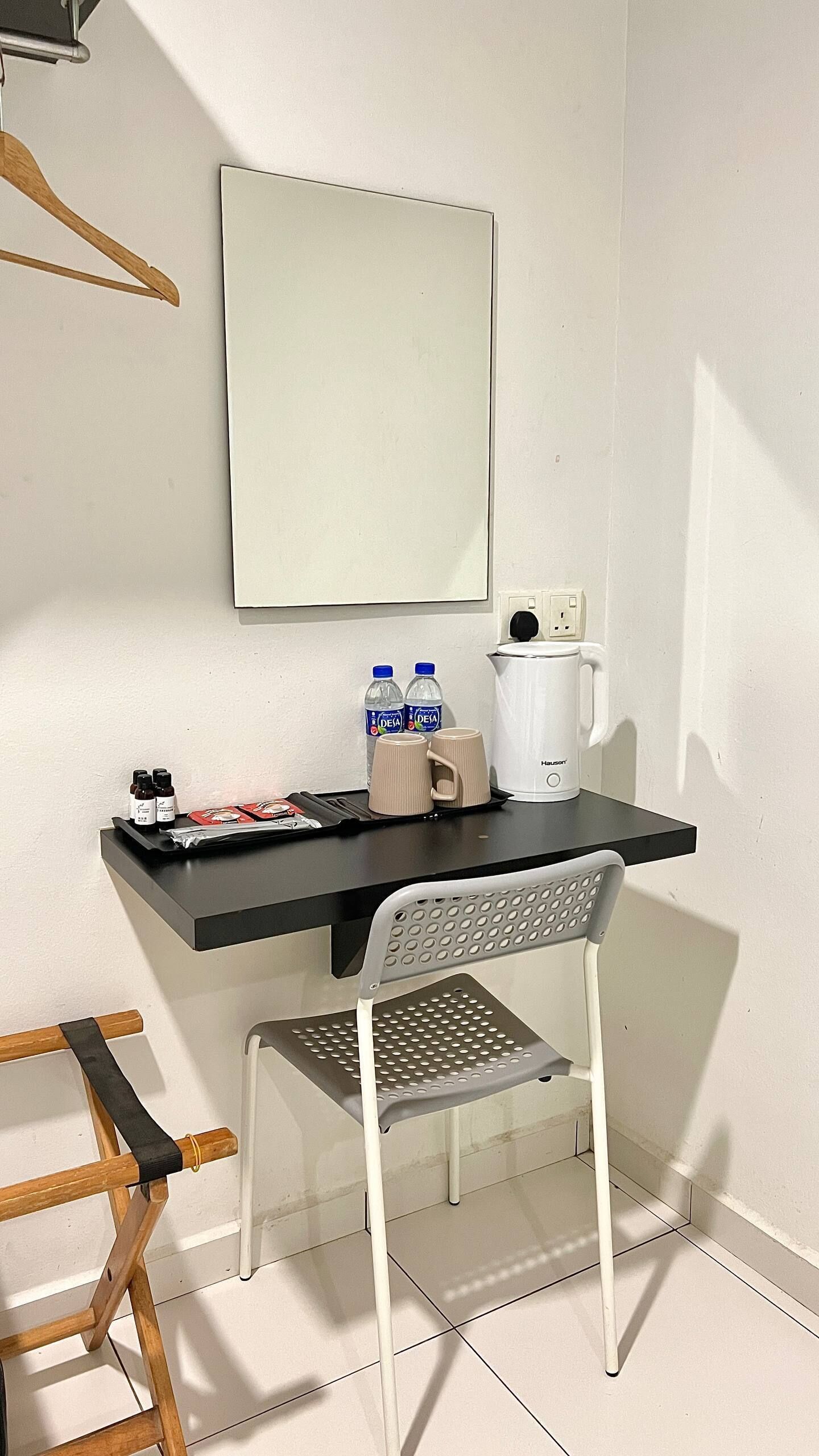 A small, neatly arranged workspace with a desk, chair, and a coffee maker.