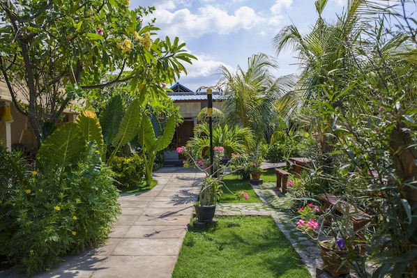 A garden pathway leading to a building with a tiled roof.