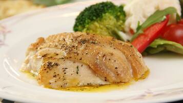 A plate with a piece of fish, broccoli, and a small salad.