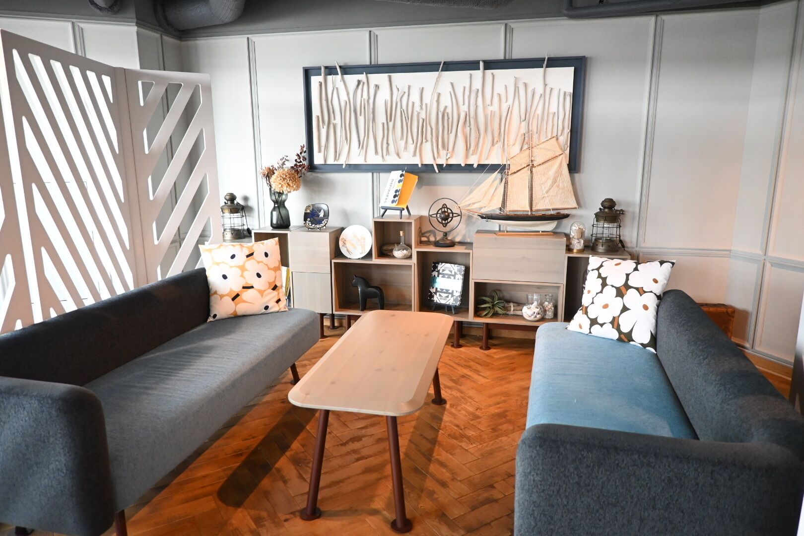 En moderne stue med to sofaer, et sofabord og en bogreol.