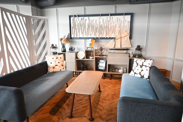 Un salon moderne avec deux canapés, une table basse et une bibliothèque.