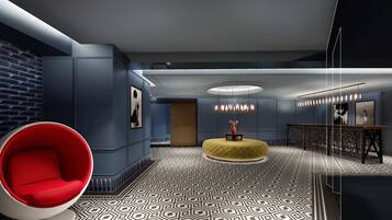 A modern interior with a red chair, a yellow ottoman, and a patterned floor.