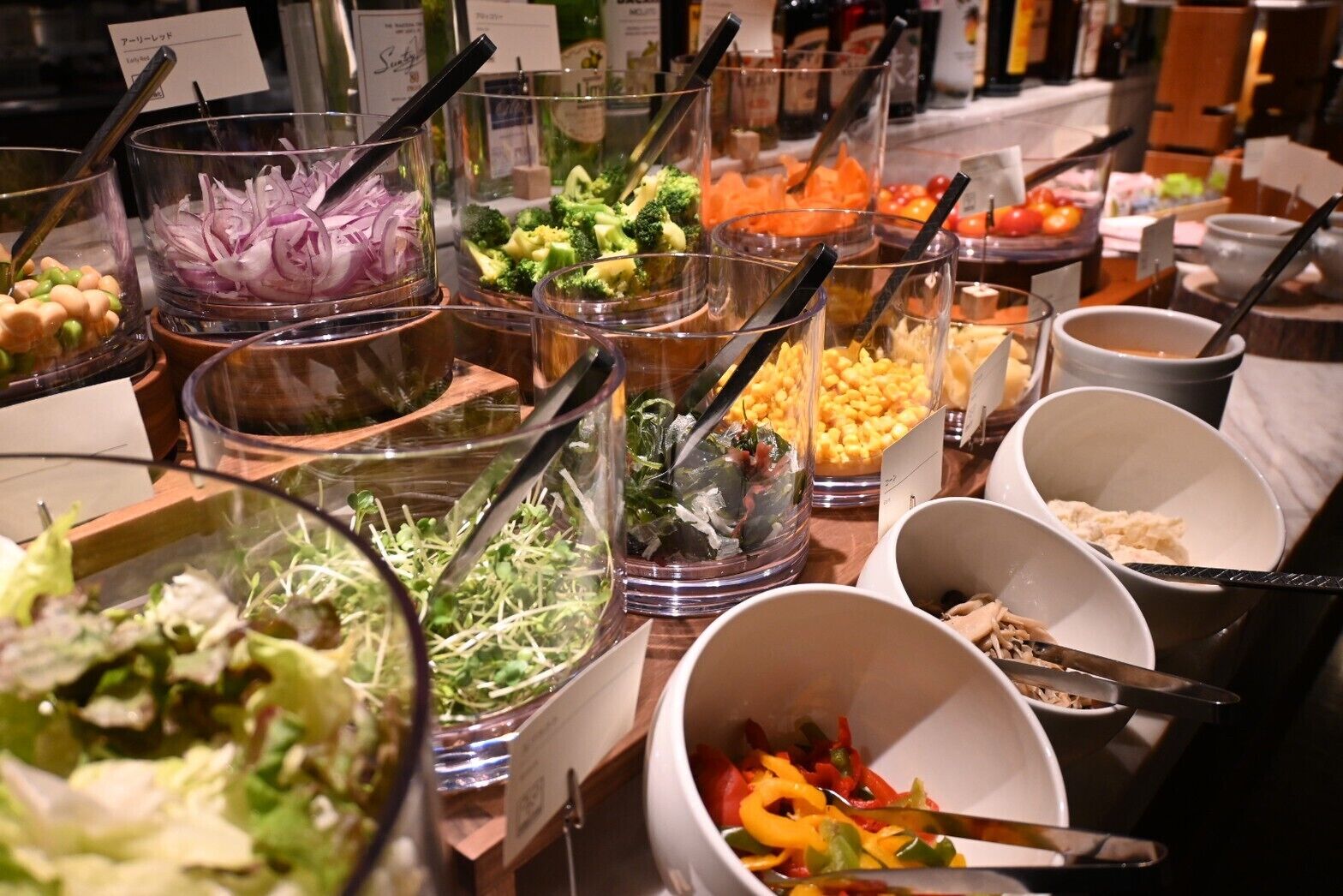 Ein reichhaltiges Buffet mit verschiedenen Speisen, darunter Salate, Gemüse und Getreide.