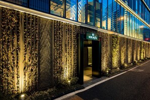 A modern hotel facade with vertical gardens and a prominent entrance.
